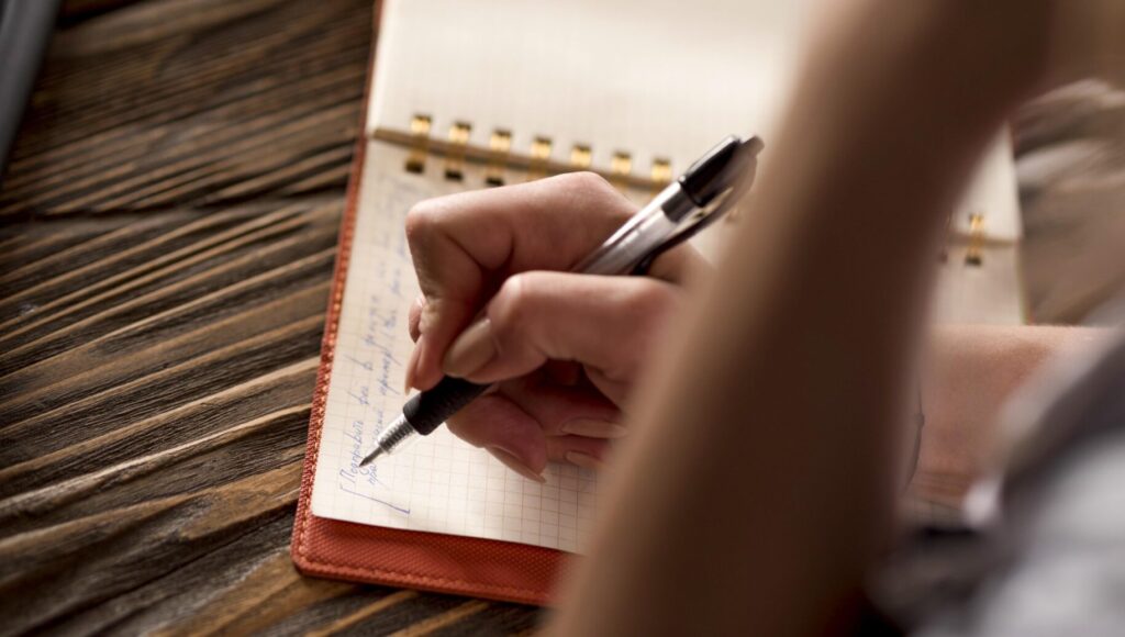 close-up-woman-writing-agenda